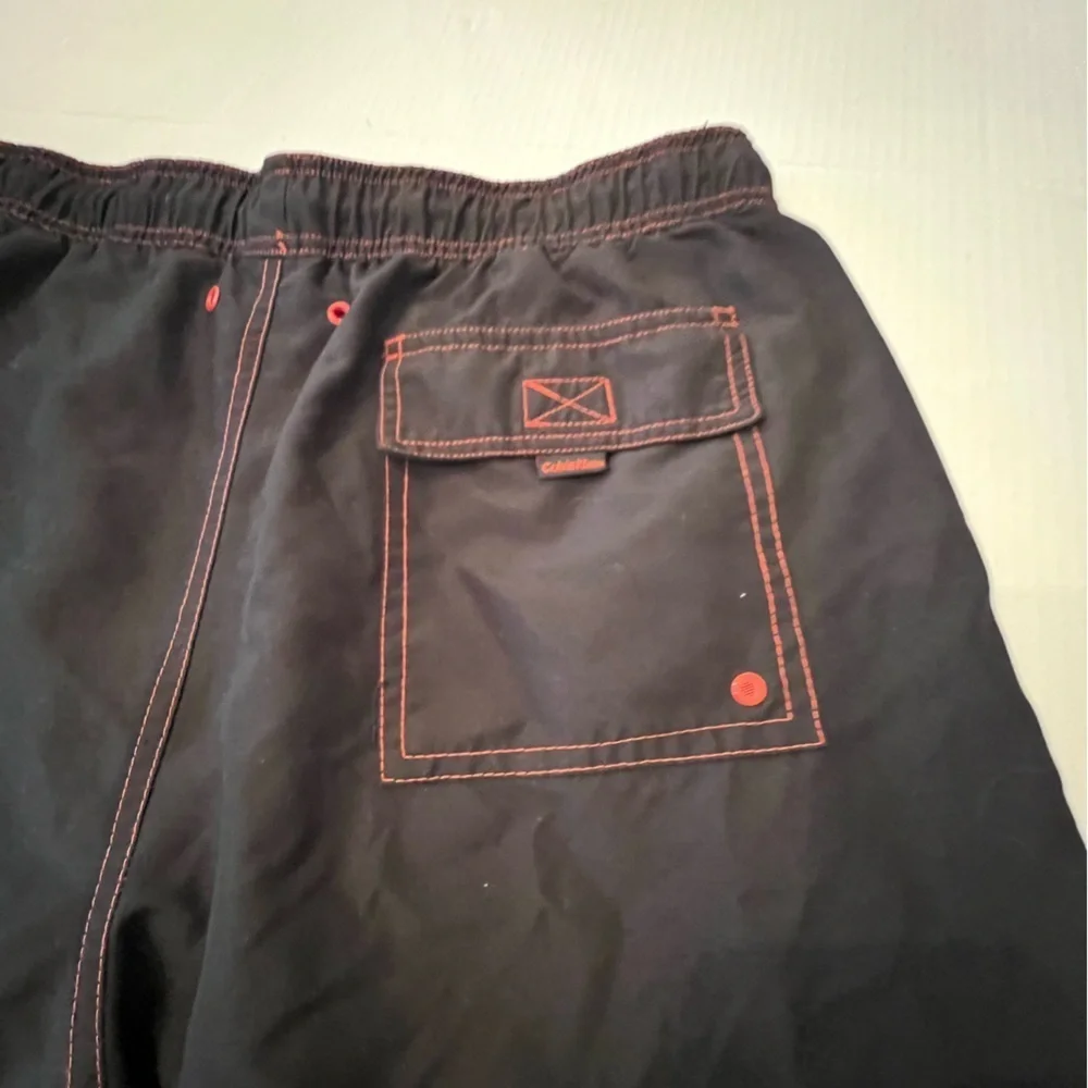 CALVIN KLEIN MENS SWIM TRUNKS. SIZE MEDIUM. BLACK WITH ORANGE STITCHING